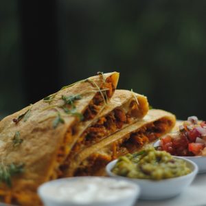 a plate topped with a quesadilla cut in half