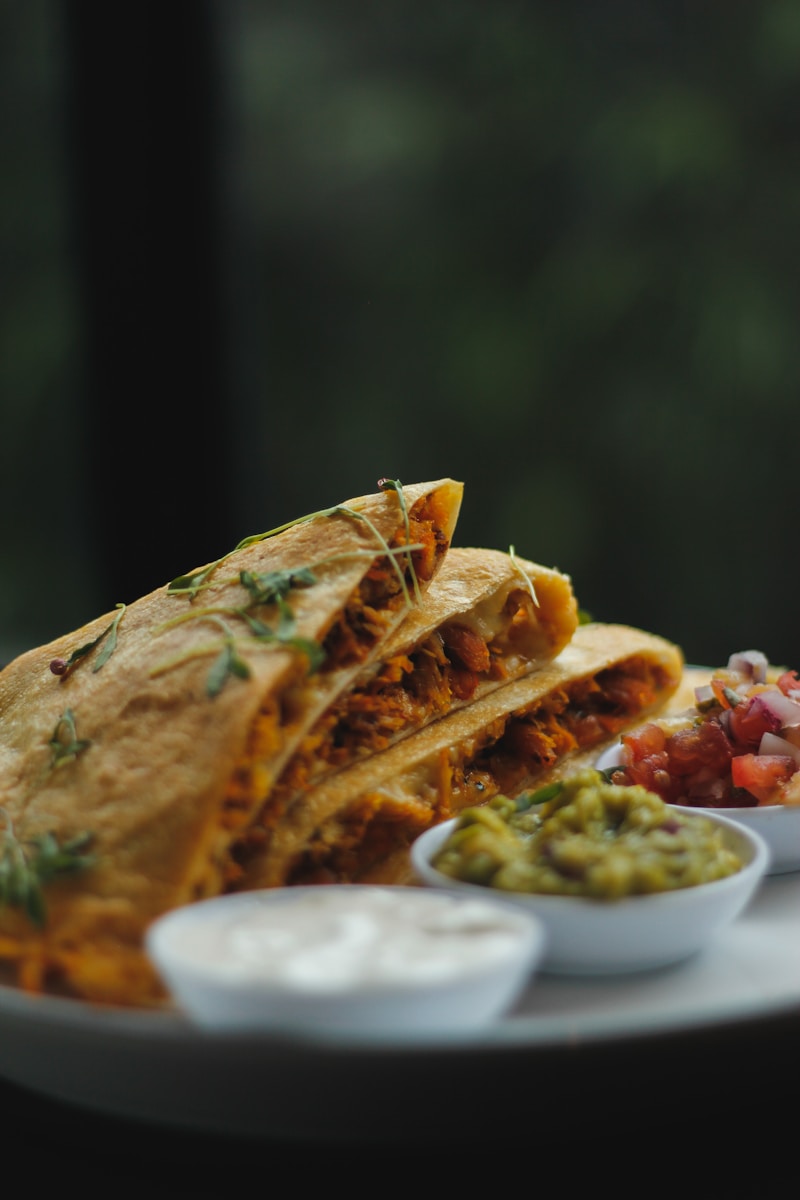 a plate topped with a quesadilla cut in half